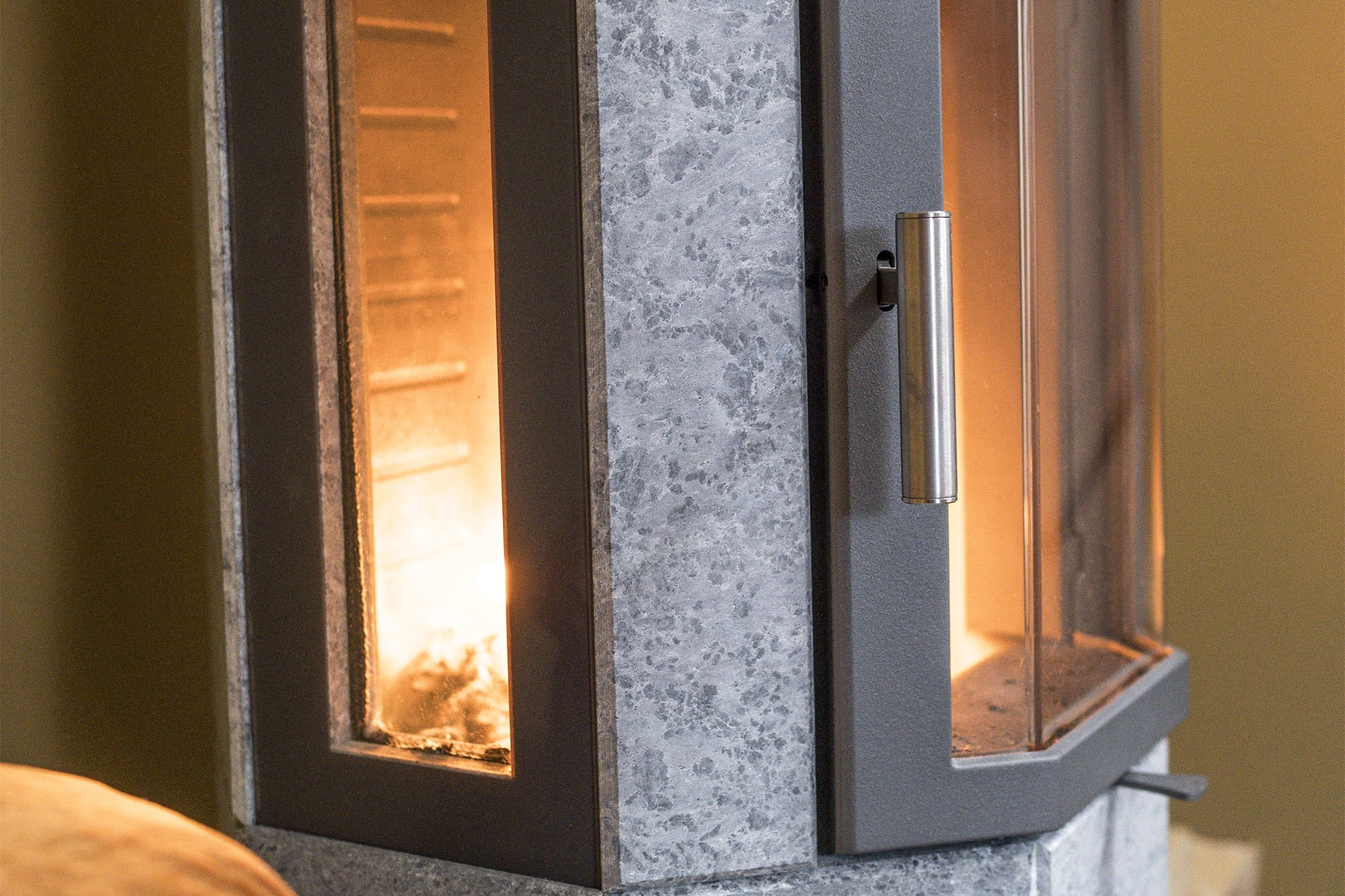 Die Seitenfenster sind ein attraktives Designmerkmal. Sie sind elegant einen Zentimeter zurück versetzt und direkt in den Stein eingepasst ohne die Notwendigkeit eines Metallrahmens. Dies verleiht dem Ofen ein stilvolles und hochwertiges Aussehen.